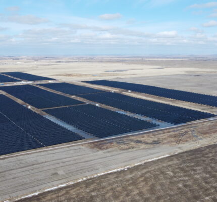 Vue aérienne du parc solaire Duchess avec des rangées de panneaux solaires sur un paysage de prairie.