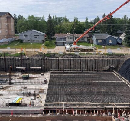 Un chantier de construction où des travailleurs et des machines s'affairent à la construction d'une nouvelle installation de traitement des eaux dans un milieu urbain.