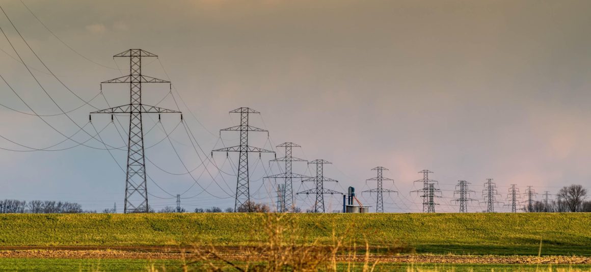 Coucher de soleil avec tours de transport et lignes électriques.