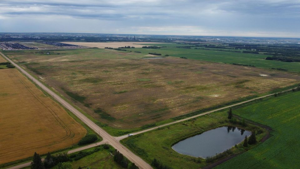 Vue aérienne du site du terminal de Sturgeon Ouest. Image d’un terrain vague avec des routes et un étang au premier plan.