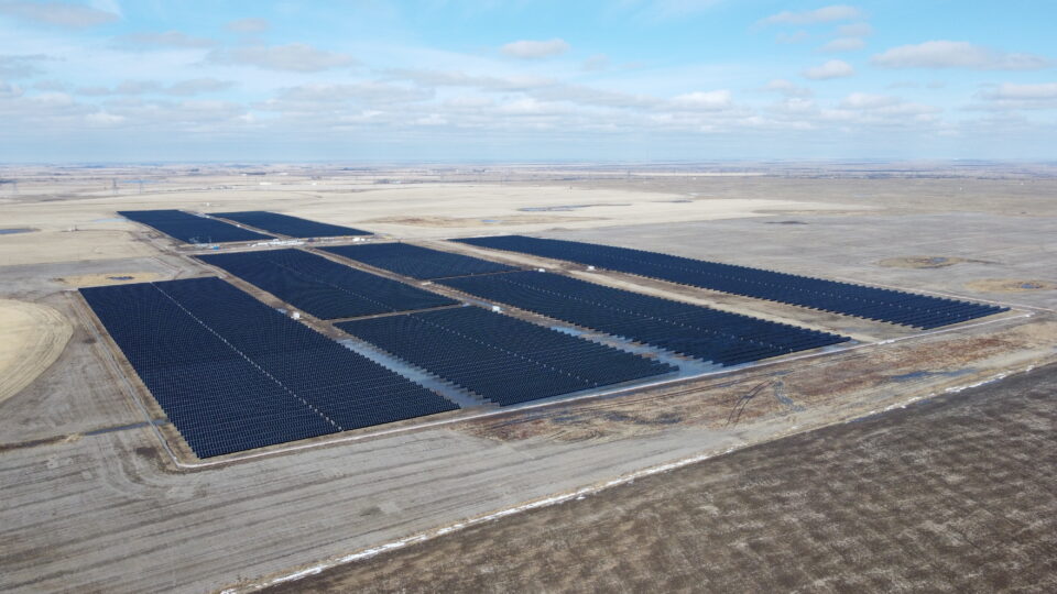Vue aérienne du parc solaire Duchess avec des rangées de panneaux solaires sur un paysage de prairie.