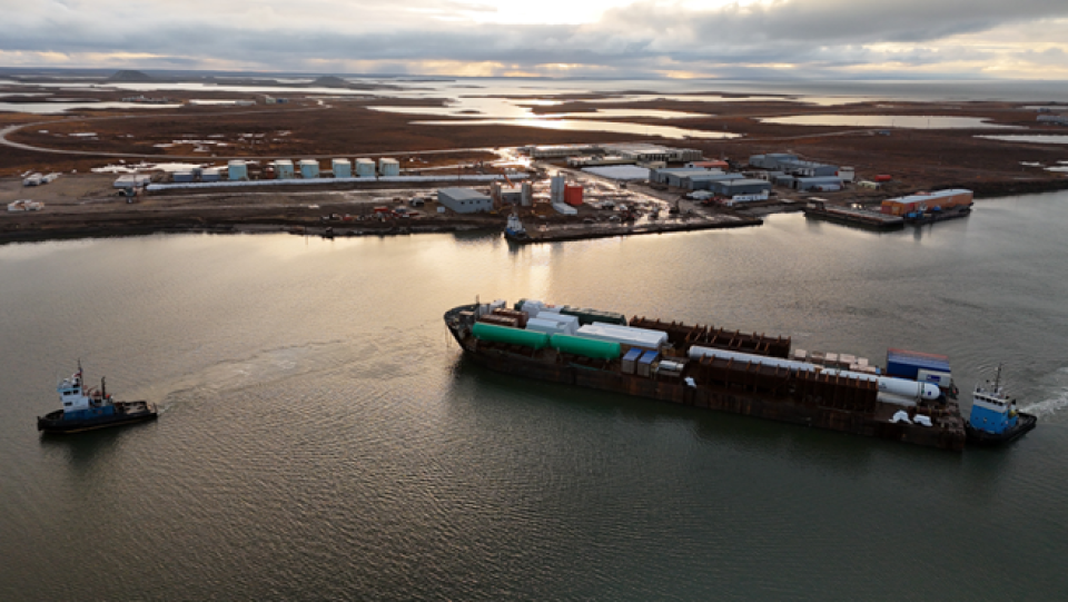 Aerial view of a barge arriving with supplies to the Tuktoyaktuk port.