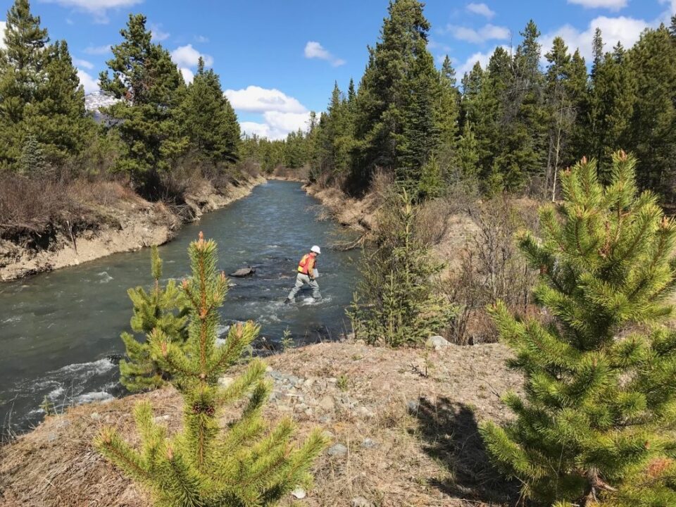 Worker crossing natural canal at the Atlin Hydroelectric site in Northern Canada