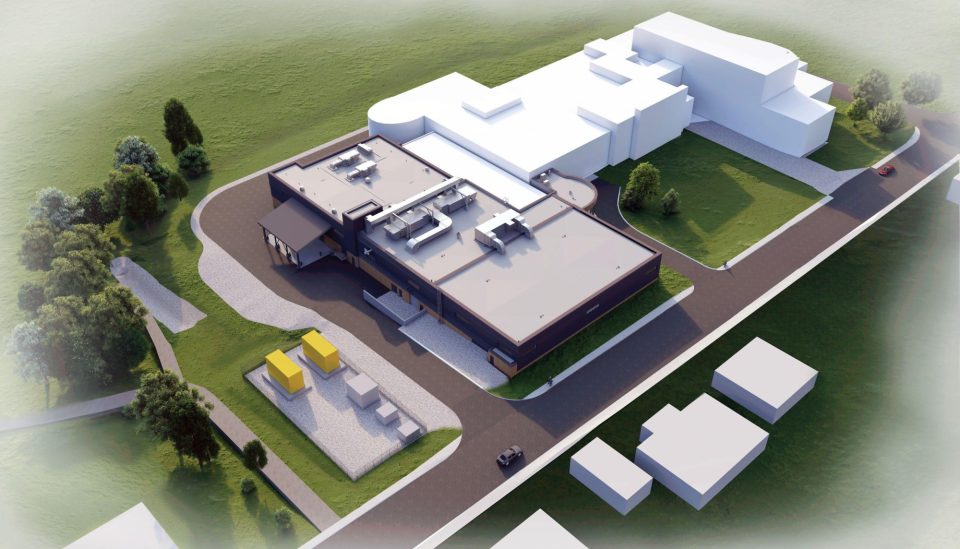 Rendu architectural aérien du projet d’infrastructures liées à l’eau de Brandon, un bâtiment à toit plat et à façade sombre adjacent à une structure blanche plus grande, entouré d’espaces verts et d’allées asphaltées.