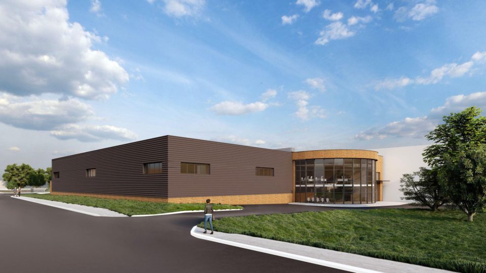 Rendu architectural du projet d’infrastructures liées à l’eau de Brandon, un bâtiment commercial moderne avec un revêtement extérieur brun foncé, une entrée en verre incurvée et un aménagement paysager sous un ciel bleu partiellement nuageux.