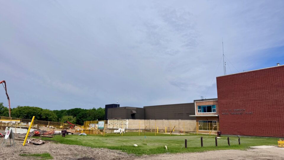 A construction site featuring a building in progress, with a crane visible in the background.