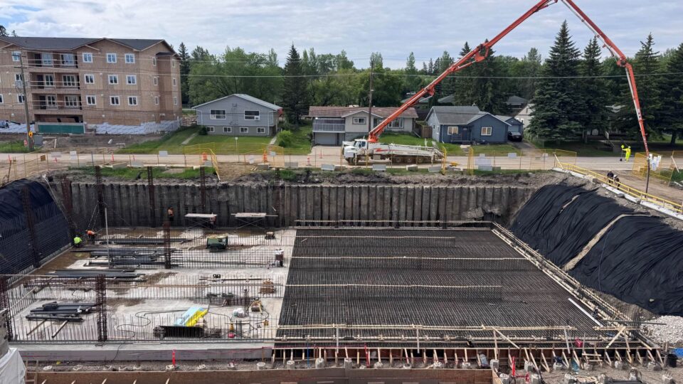A construction site featuring workers and machinery as they build a new water treatment facility in an urban area.