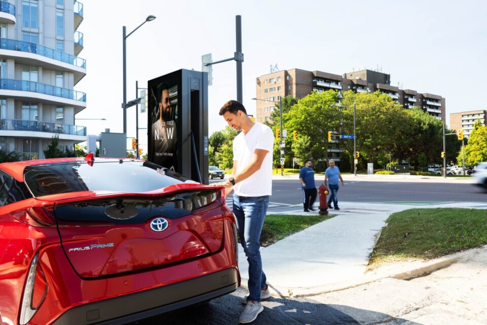 Homme en train de recharger sa voiture rouge à une station de recharge de VE de JOLT à Richmond Hill (Ontario)