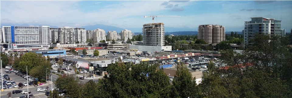L'horizon d'une ville avec des immeubles à appartements à l'arrière-plan et un bâtiment en construction au premier plan, avec des arbres