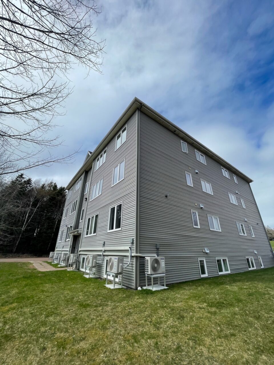Side of grey student Housing building in Sackville, New Brunswick with blue sky