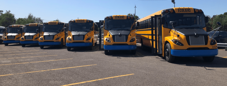 Une rangée d'autobus scolaires électriques au Québec