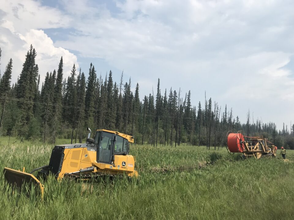 Machine d'excavation tirant une charrue dans un fossé