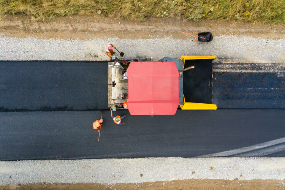 Vue aérienne d’une nouvelle route avec des machines de pose d’asphalte