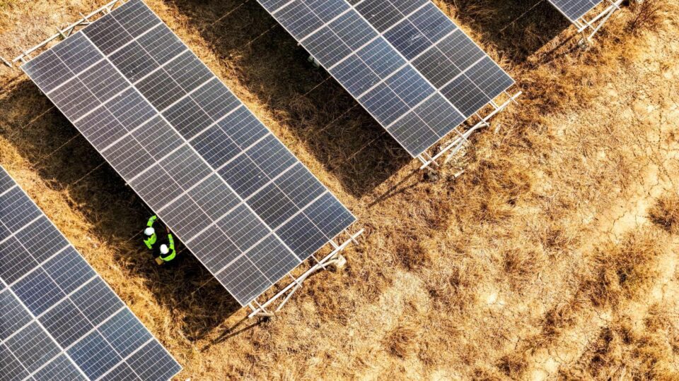 Aeriel photo of solar panels on a brown field.