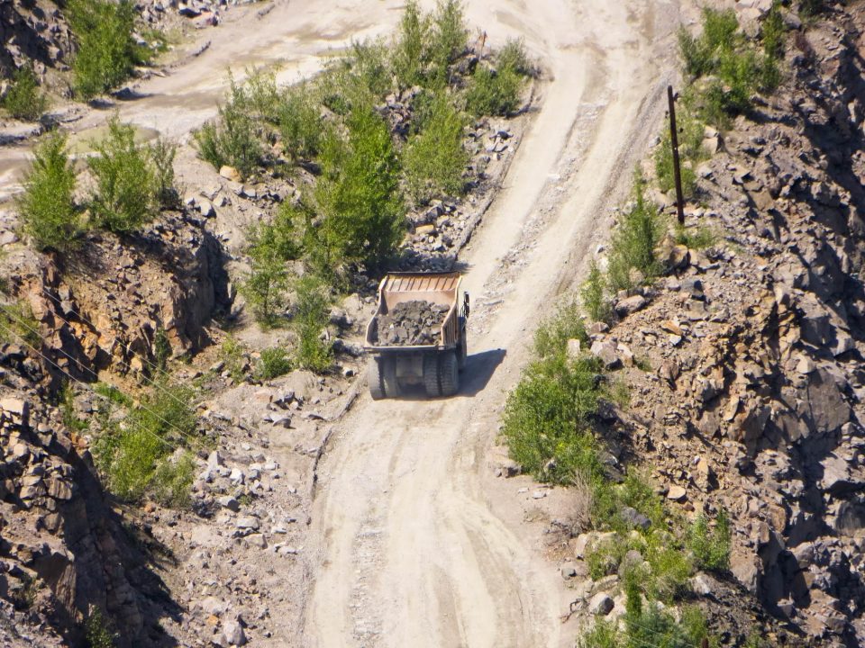 Truck hauling materials on a dirt road.