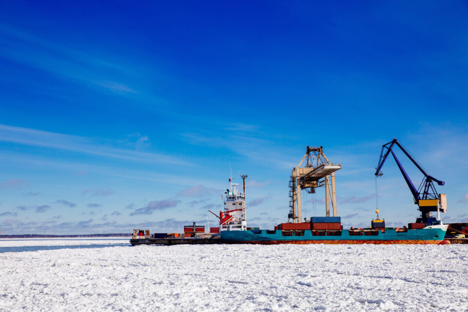 Industrial arctic port with machinery and ships.