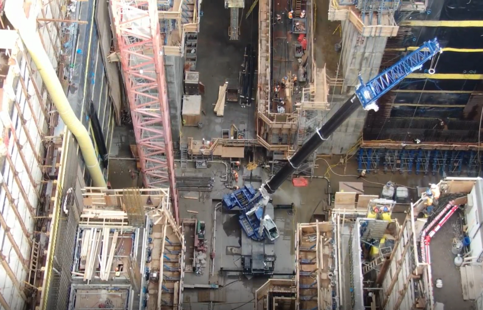 Large cranes enable work crews to operate in a deep open shaft to build the tunnel and station for the REM at Montreal’s Trudeau International Airport.