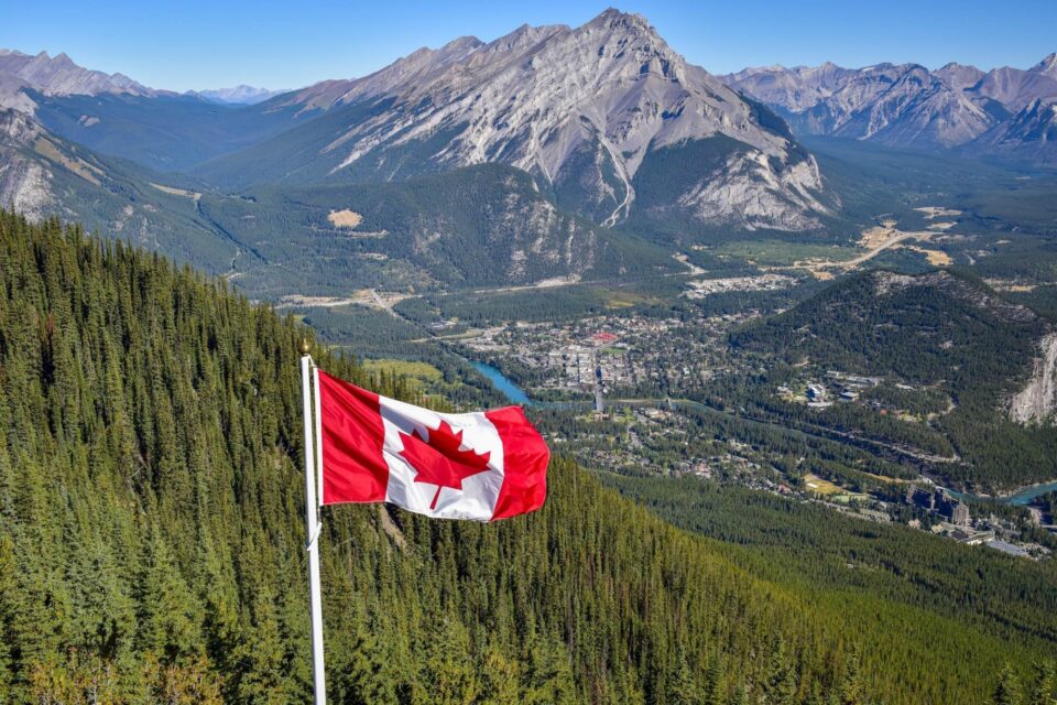 Drapeau canadien avec montagne et arbres derrière